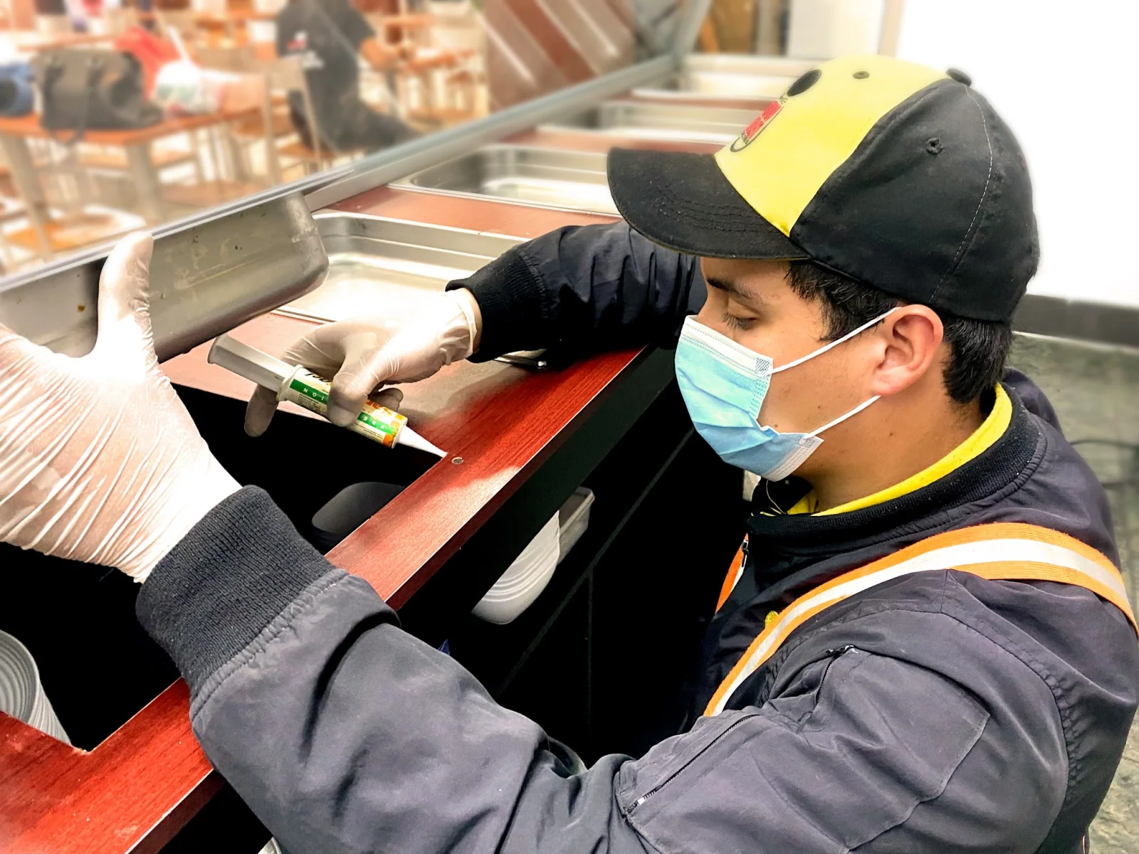 Técnico de Truly Nolen Guatemala aplicando un tratamiento bajo un mostrador